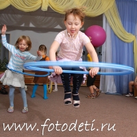 Ребёнок высоко прыгает через обруч, на фото дети занимаются спортом